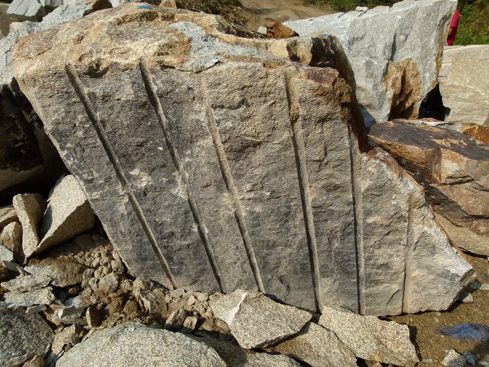 Entlang der Bohrlöcher gespaltener Granitquader
