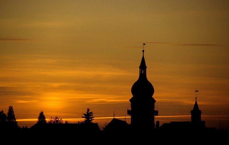 Sonnenuntergang hinter der Altstadt mit Kirche und Rathaus