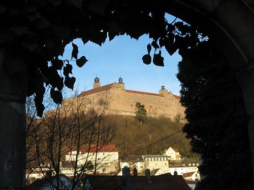 Blick auf die Plassenburg durch einen Durchgang in der alten Kulmbacher Stadtmauer
